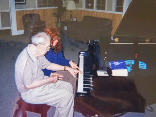 Senior Man Playing Piano with Woman Helper