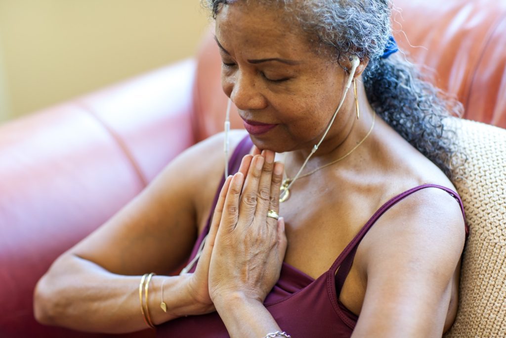 Woman meditating wearing ear buds